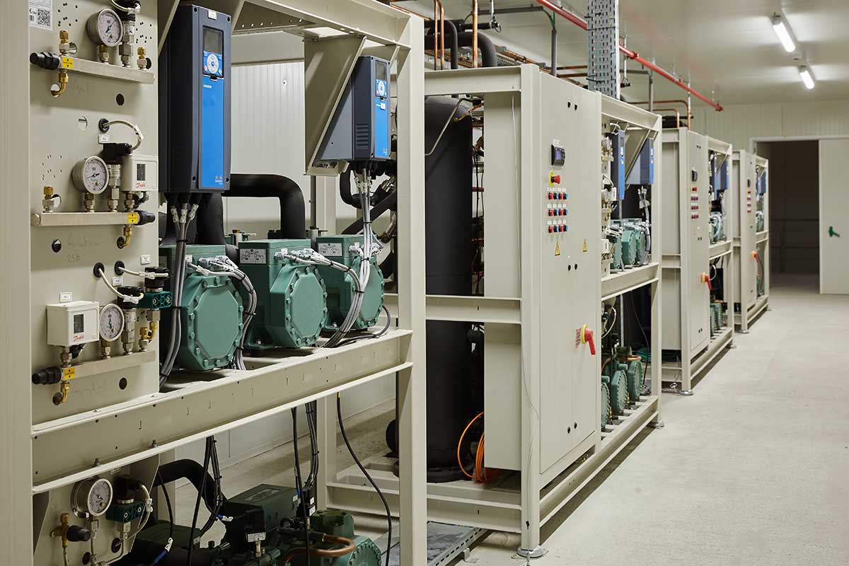 Industriële koelinstallatie met geavanceerde koeltechniek, inclusief compressoren en regelpanelen, in een technische ruimte. Efficiënte en duurzame koelsystemen voor industrie en commerciële toepassingen.