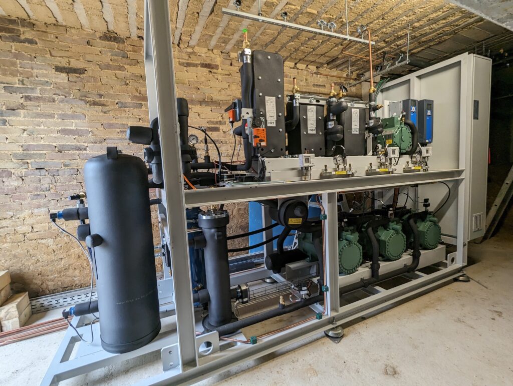 Industriële CO₂-koelinstallatie in technische ruimte met compressoren, leidingen en regelpanelen voor duurzame en energiezuinige koeling.