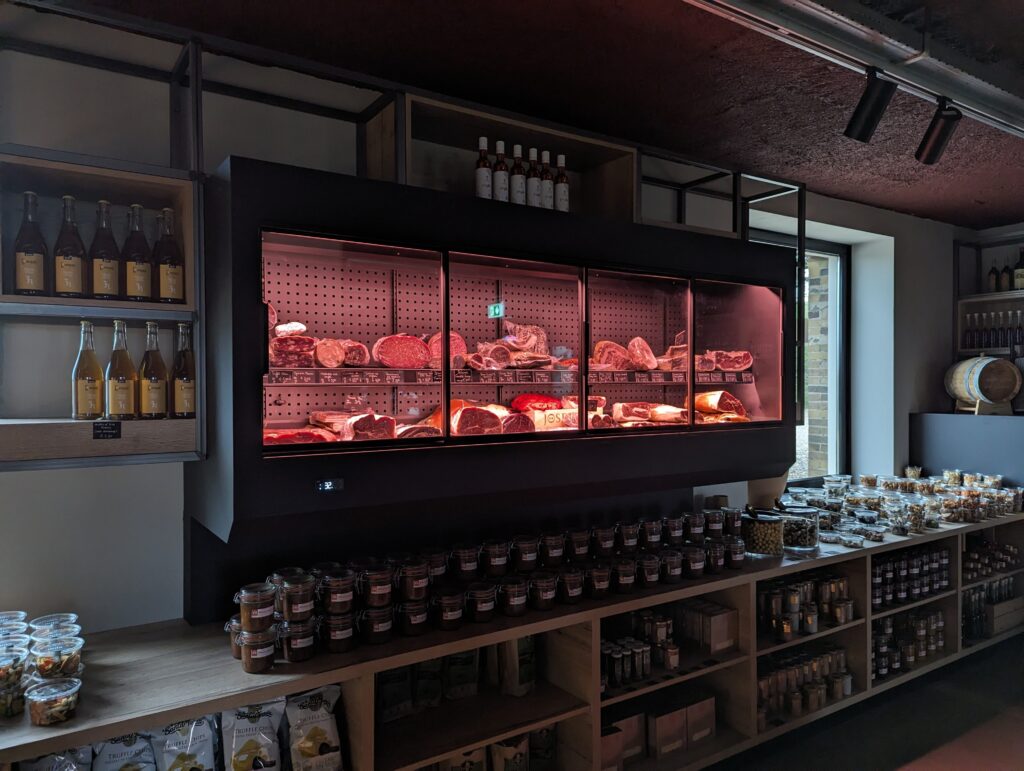 Commerciële wandkoeling voor vleesproducten in een delicatessenwinkel, met een stijlvolle koelinstallatie voor optimale bewaring.